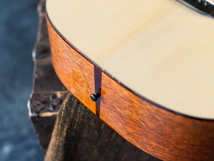 Acoustic dreadnought guitar handcrafted of mahogany back and sides with an adirondack top. Closeup