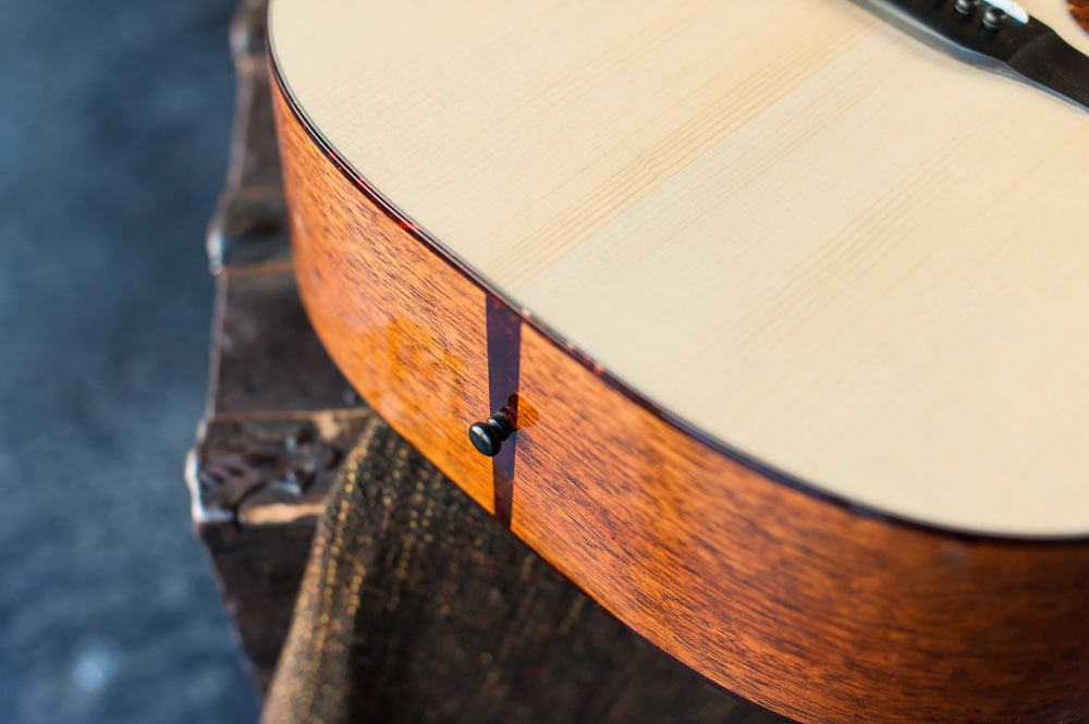 Acoustic dreadnought guitar handcrafted of mahogany back and sides with an adirondack top. Closeup